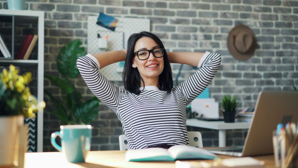 Neu als Führungskraft: Sicher und Authentisch starten. Auf dem Bild siehst du eine Frau an einem Schreibtisch.